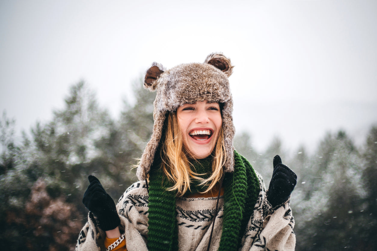 A woman wearing a winter hat to protect her hair.